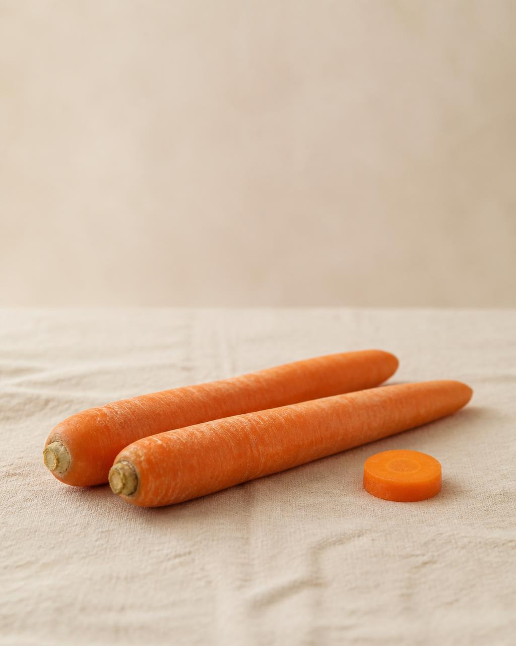 Two whole carrots with a single slice beside them