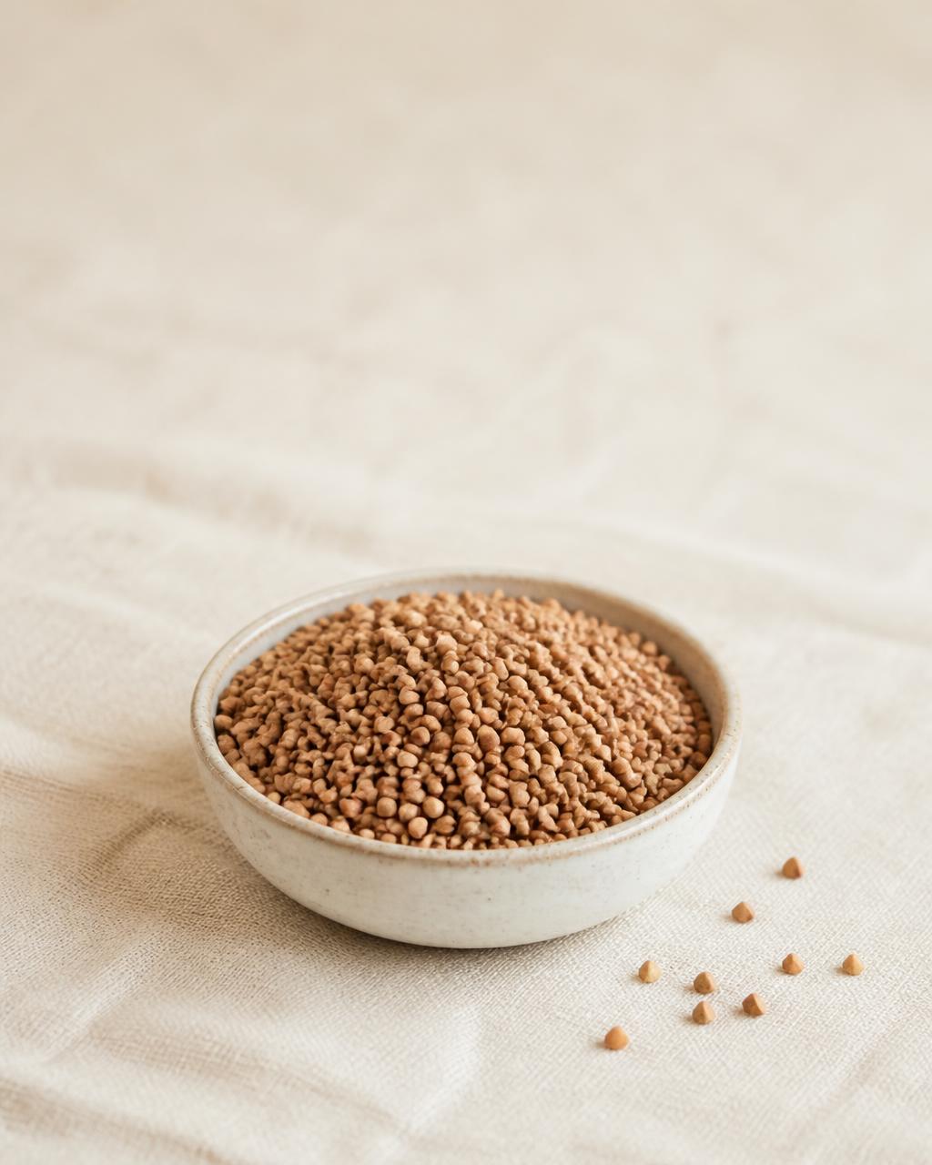 Raw buckwheat groats in a small ceramic bowl