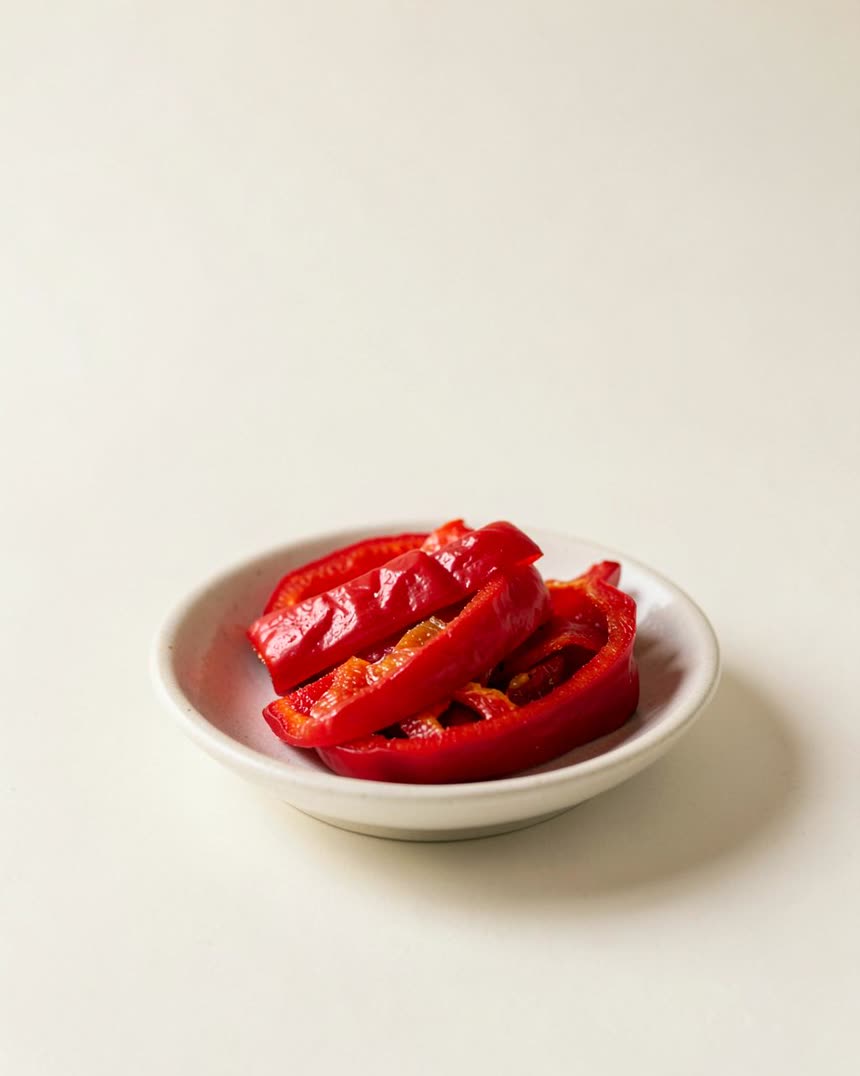 Roasted red peppers, jarred on a light neutral background